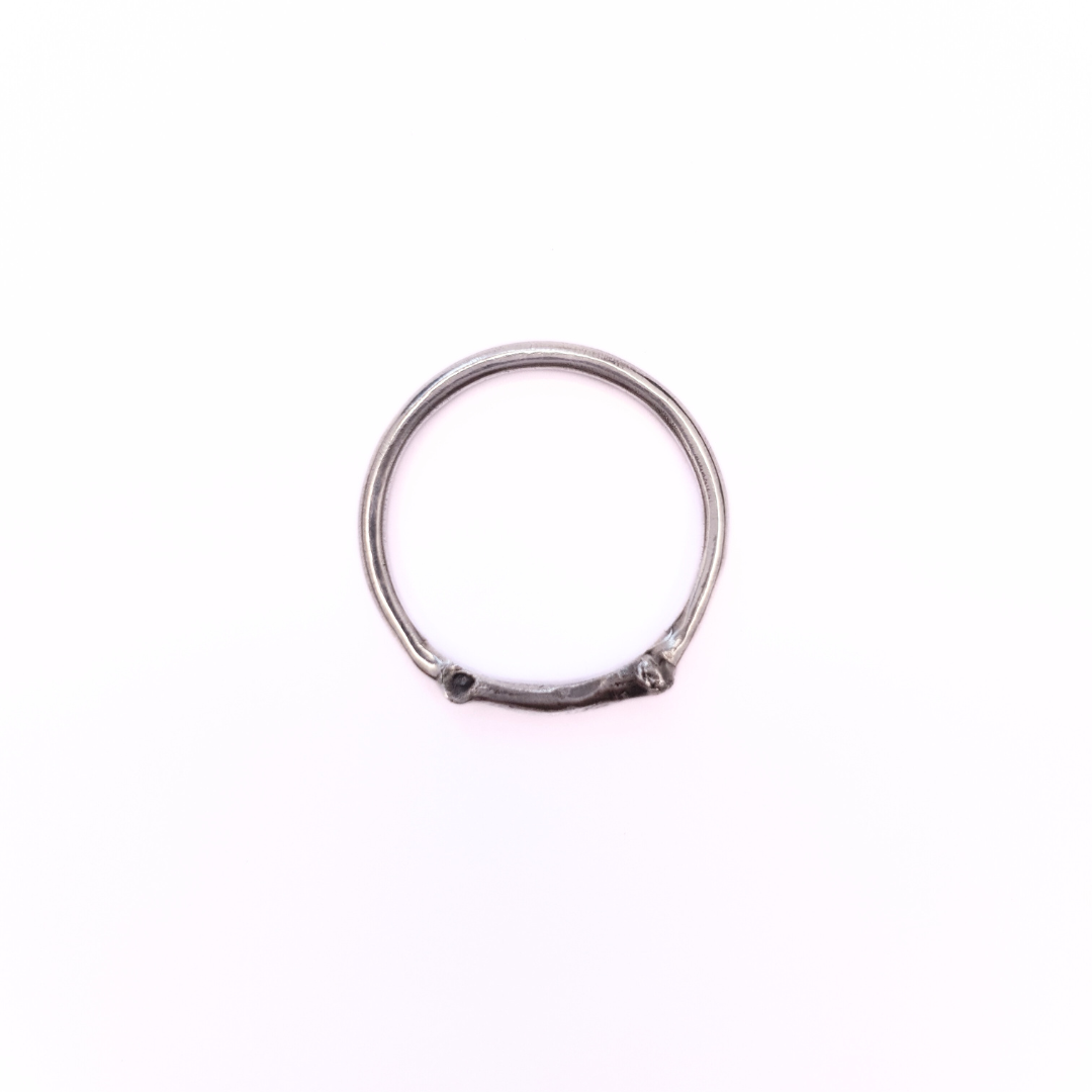A silver ring is photographed from above on plain white background. Part of the band of the ring is the solid silver casting of a little bone. The details are oxidised to show all the beautiful natural texture.
The angle of the photo demonstrates the smooth inside-profile of the ring to reassure the viewer that it's comfortable to wear and won't dig in.