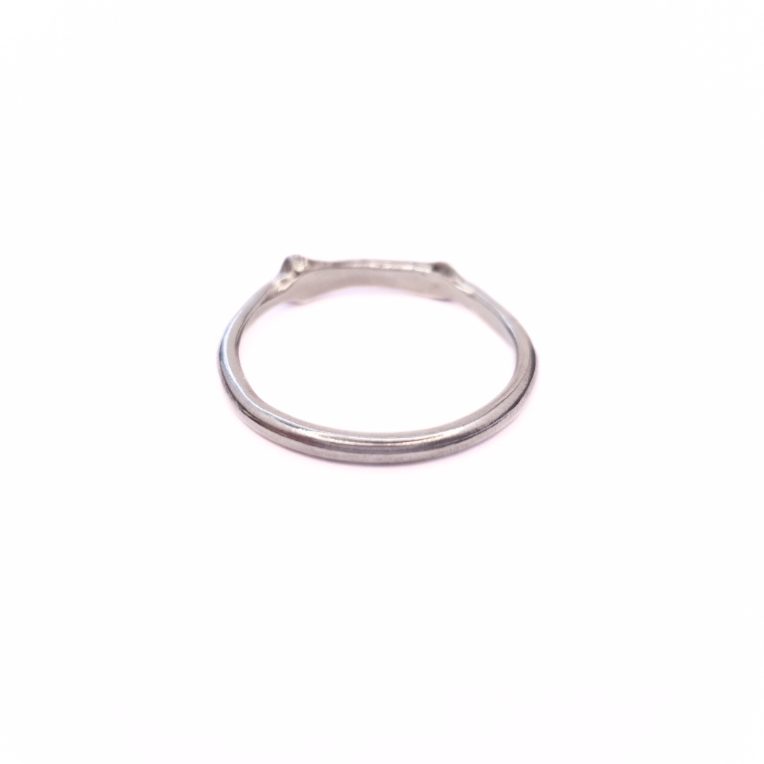A silver ring is photographed from behind on plain white background. Part of the band of the ring is the solid silver casting of a little bone. 
The angle of the photo demonstrates the smooth inside-profile of the ring to reassure the viewer that it's comfortable to wear and won't dig in.