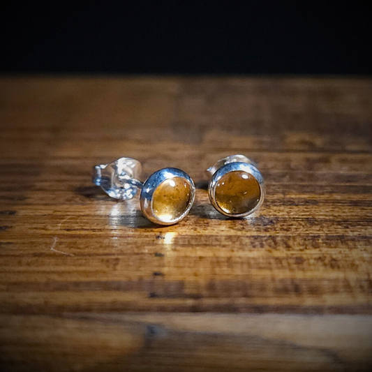 Golden citrine & sterling Silver round stud earrings on a wooden surface