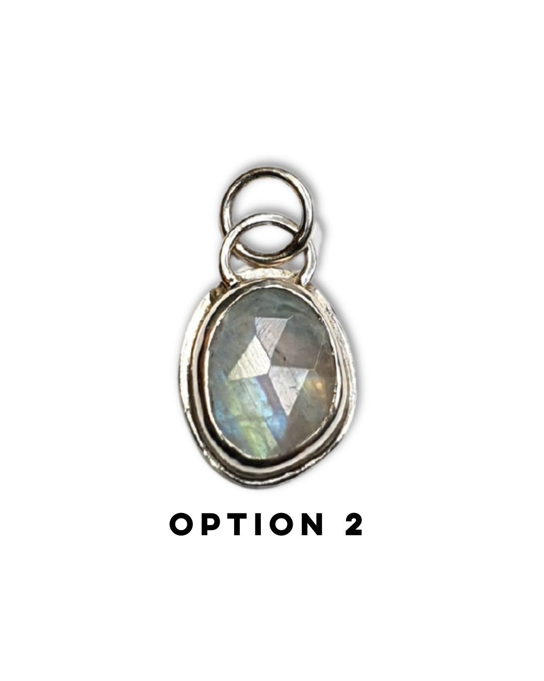 An irregular, oval-shaped rainbow moonstone is bezel set in silver and sits on a white background. The gemstone is rose-cut and the facets shine in the light displaying a beautiful show of rainbow iridescence. There is a large circular silver bail at the top with a similarly large jump ring attached. There is text below which reads "OPTION 2"