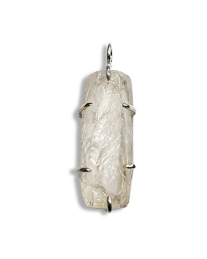 A rough-cut, semi-transparent, rectangle-shaped quartz pendant is photographed on a white background. The rough, beautifully textured stone is set in 6 silver claws - 1 and the top and bottom and two on each side. A silver jump ring is visible at the top.