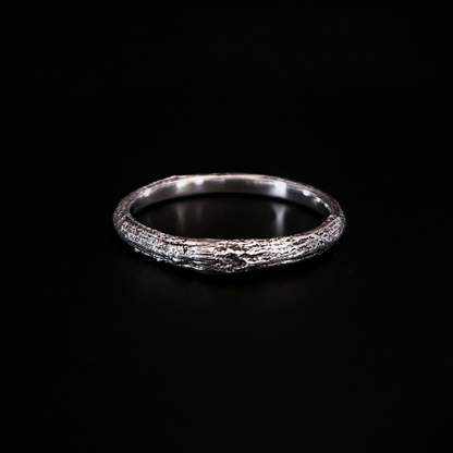 A wood-textured sterling silver band ring shown on a solid black background. The recesses have been oxidised black to reveal the gorgeous oak bark casting on the surface and the inside of the band is completely smooth for comfort.