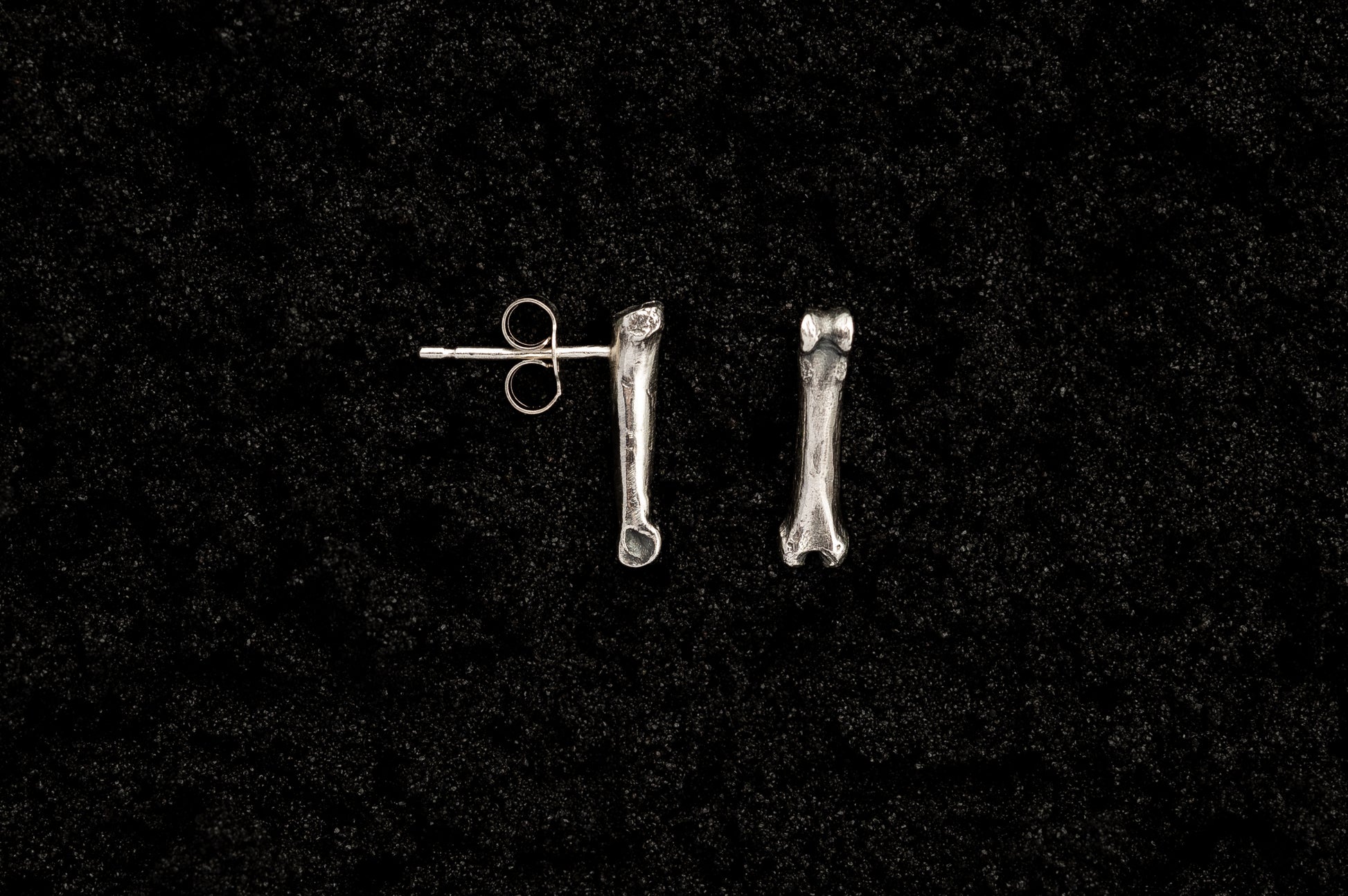 Silver Bone Studs on Black Sand