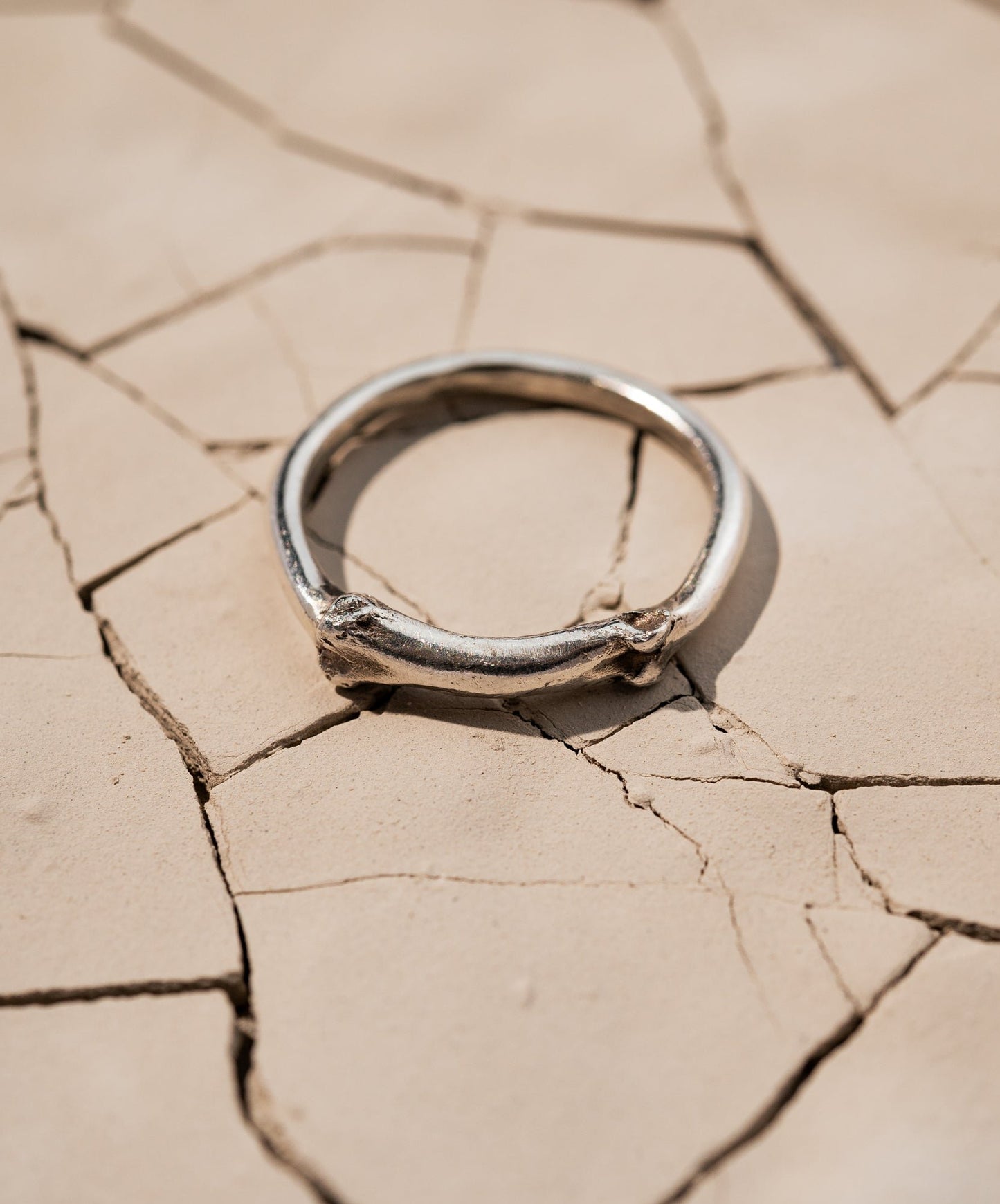 Sterling silver Bone Ring Laying on Cracked Desert Earth