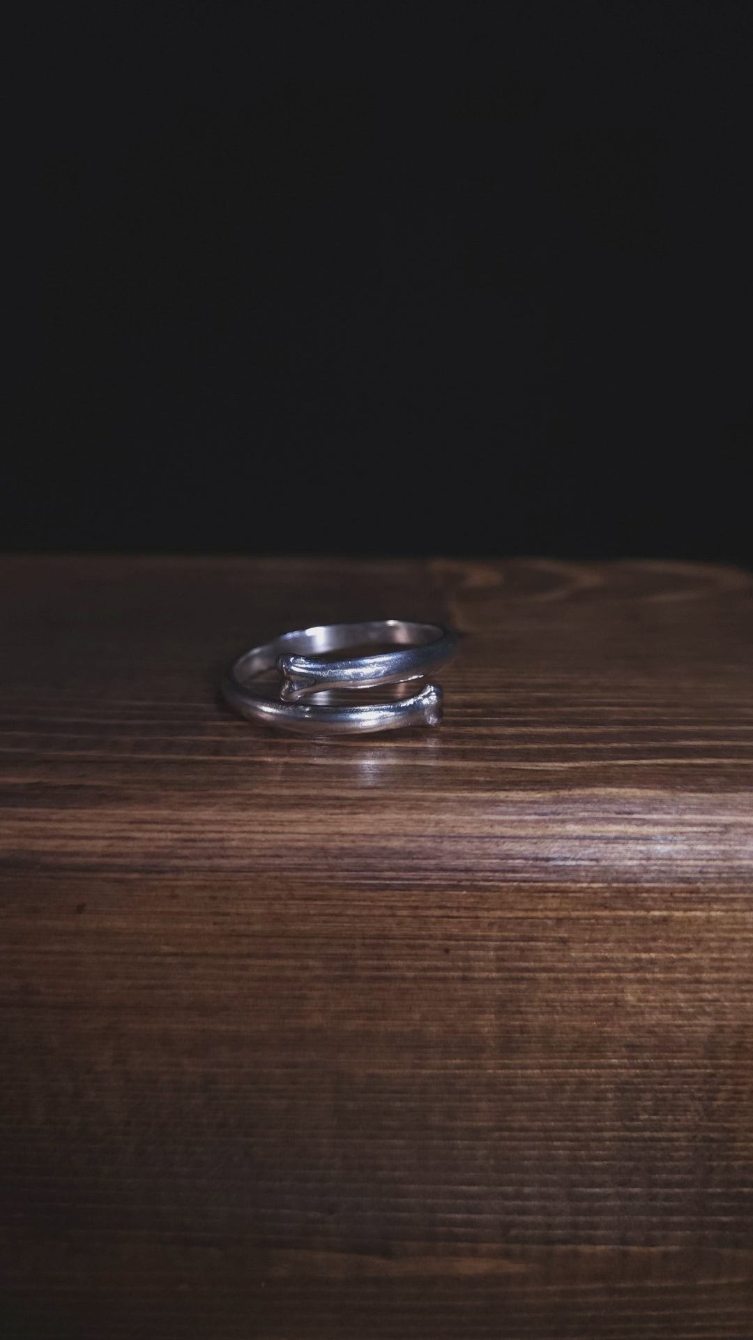 A stop motion style video shows an open bone ring in sterling silver. It is rotating to show the ring from all angles.