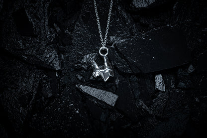 A silver necklace made from the casting of a baby fox tooth sits on a background of wet, black slate. The photograph is taken from the top down. This is a stunning taxidermy style pendant for fans of alternative jewellery, folklore and witchy, gothic aesthetics.